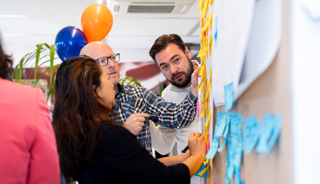 Mensen aan een scrum bord in overleg