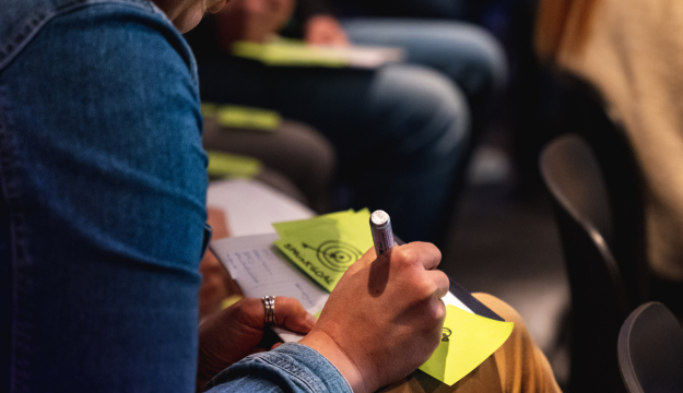 Persoon schrijft op sticky