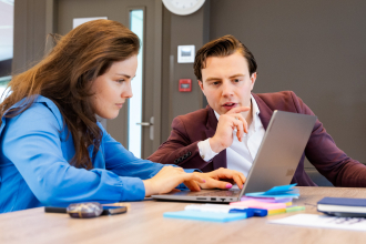 Twee mensen bij een Laptop